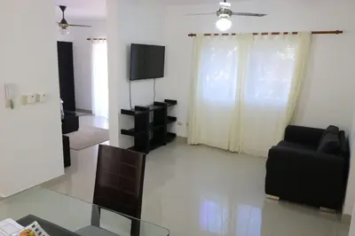 a living room with a tv and a couch and a chair at Tu Segundo Hogar en Santiago, La Cuidad CORAZÓN in Santiago de los Caballeros