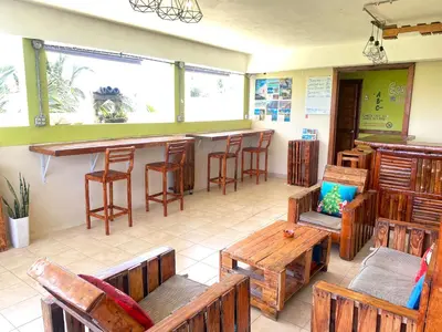 a restaurant with wooden tables and chairs and a bar at Private Rooms-Art Punta Cana in Punta Cana