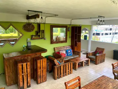 a living room with wooden furniture and green walls at Private Rooms-Art Punta Cana in Punta Cana