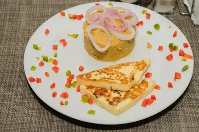 a plate of food with a sandwich and onion rings at Hostal San Francisco de Asis in Santo Domingo