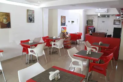 a restaurant with red and white tables and chairs at Hostal San Francisco de Asis in Santo Domingo