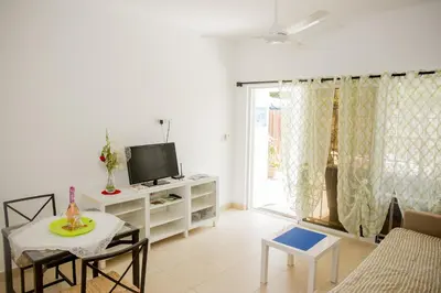 a living room with a tv and a table with chairs at Bela Villa Apartment IDA in Bayahibe