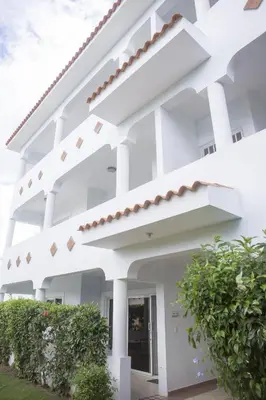 a white building with white columns at Bela Villa Apartment IDA in Bayahibe