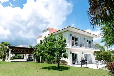 a white house with a tree in front of it at Luxury Villa Iberosta Del Mar - 4BDR, Private Beach, Pool & Jacuzzi in Punta Cana