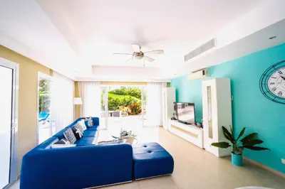 a blue living room with a blue couch and a tv at Luxury Villa Iberosta Del Mar - 4BDR, Private Beach, Pool & Jacuzzi in Punta Cana