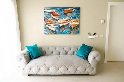 a couch in a living room with a painting of boats at Luxury Villa Iberosta Del Mar - 4BDR, Private Beach, Pool & Jacuzzi in Punta Cana