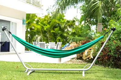 a hammock in a yard in front of a house at Luxury Villa Iberosta Del Mar - 4BDR, Private Beach, Pool & Jacuzzi in Punta Cana