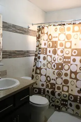 a bathroom with a toilet and a shower curtain at Apartamento Amueblado Amplio Tranquilo Privado Como tu lo Mereces in Santiago de los Caballeros