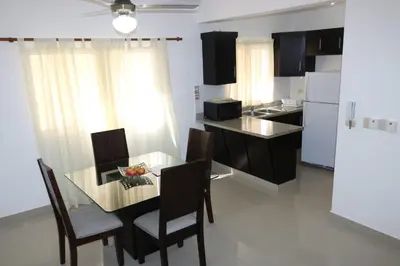 a kitchen with a glass table and chairs and a counter at Apartamento Amueblado Amplio Tranquilo Privado Como tu lo Mereces in Santiago de los Caballeros