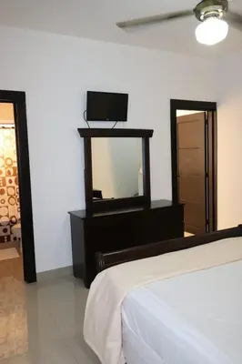 a bedroom with a bed and a dresser with a mirror at Apartamento Amueblado Amplio Tranquilo Privado Como tu lo Mereces in Santiago de los Caballeros