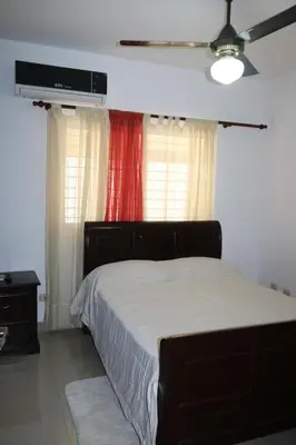 a bedroom with a bed and a tv on the wall at Apartamento Amueblado Amplio Tranquilo Privado Como tu lo Mereces in Santiago de los Caballeros