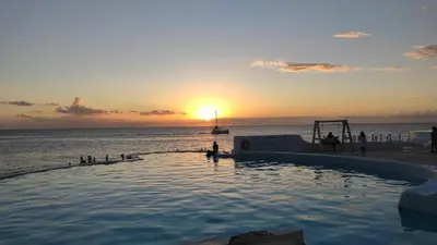 a swimming pool with the sunset in the ocean at Million View Room Adults Only Resort 1 in La Laguna