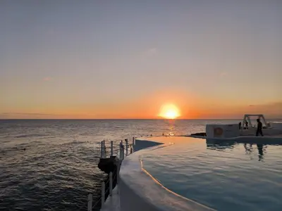 a infinity pool in the ocean at sunset at Million View Room Adults Only Resort 1 in La Laguna