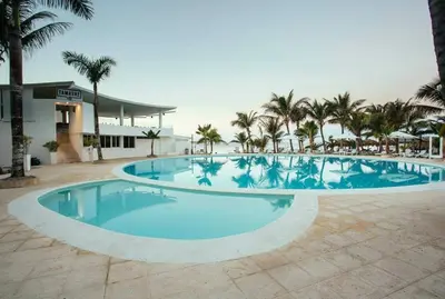 a large swimming pool with palm trees and a building at Espectacular Apartamento con Vista al Mar Solo Adultos in La Laguna