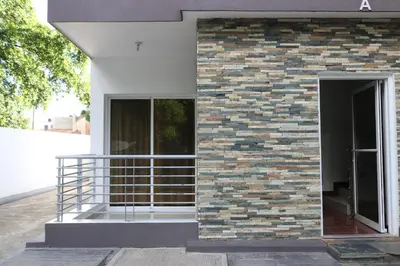 a brick wall with a metal railing next to a building at Apartamento Amueblado Amplio Tranquilo Privado Como tu lo Mereces in Santiago de los Caballeros