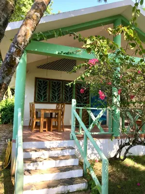 a porch of a house with a table and chairs at La Cotica Casa Verde o Casa Azul in Las Terrenas