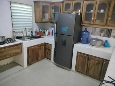 a kitchen with a refrigerator and wooden cabinets at Hotel Yamir in Santa Cruz de Barahona