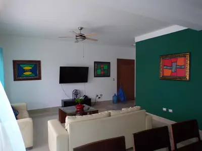 a living room with a couch and a green wall at Luxury in the Caribbean in Sosúa