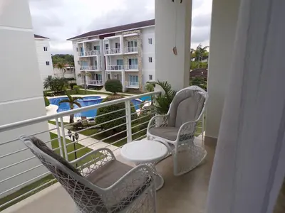 a balcony with chairs and a table and a building at Luxury in the Caribbean in Sosúa