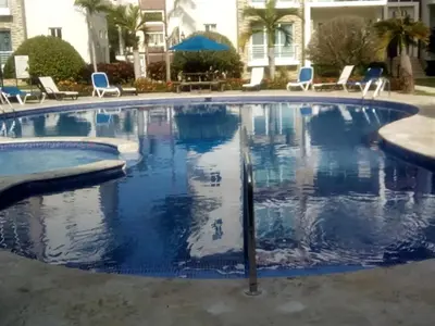 a large swimming pool with blue chairs in a hotel at Luxury in the Caribbean in Sosúa