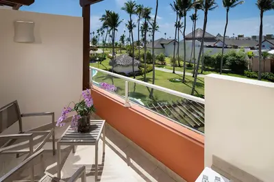 a balcony with a table and chairs and palm trees at Breathless Punta Cana Resort & Spa - Adults Only - All Inclusive in Punta Cana
