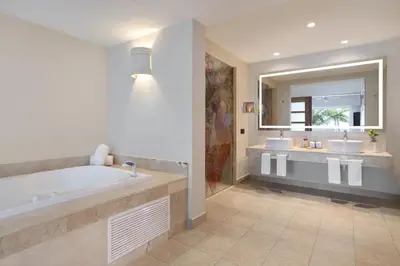 a bathroom with two sinks and a tub and a mirror at Breathless Punta Cana Resort & Spa - Adults Only - All Inclusive in Punta Cana