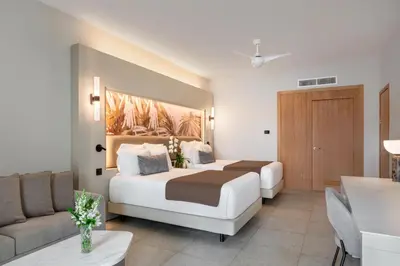 a hotel room with two beds and a couch at Breathless Punta Cana Resort & Spa - Adults Only - All Inclusive in Punta Cana