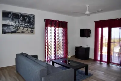 a living room with a couch and two windows at Villa Laëti in Las Terrenas