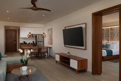a living room with a bed and a flat screen tv at Dreams Macao Beach Punta Cana - All Inclusive in Punta Cana