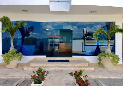 a room with two palm trees and a building at Elegante Aqua Marine Apartamento Juan Dolio in Juan Dolio