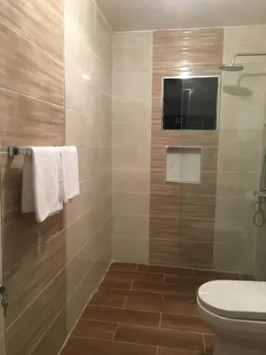 a bathroom with a toilet and a glass shower at 6-1 SANTIAGO CITY GREAT COZY APT TO STAY - Cozy 3 bedrooms Apartment for 7 peoples - close to all kind the business wifi - Air Condition in Santiago de los Caballeros