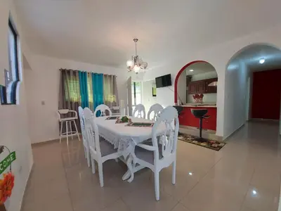 a dining room with a white table and chairs at 6-1 SANTIAGO CITY GREAT COZY APT TO STAY - Cozy 3 bedrooms Apartment for 7 peoples - close to all kind the business wifi - Air Condition in Santiago de los Caballeros