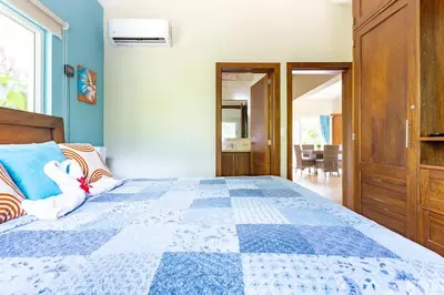 a bedroom with a bed with a blue and white quilt at 2 Bed 2 Bath Villa with Jacuzzi, High Speed Wi-Fi in Sosúa