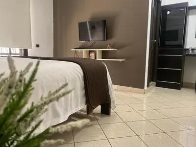 a bedroom with a bed and a flat screen tv at Ocean Breeze Studios in Santo Domingo