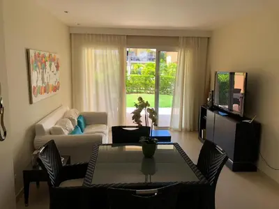 a living room with a couch and a table at Beautiful One Bedroom unit with pool and Beach club in a Golf Project in Punta Cana