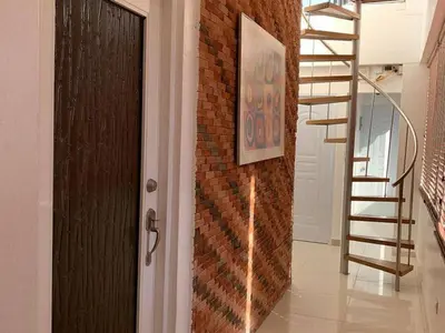 a hallway with a door and a brick wall at Cozy Private Room in El Malecn, Santo Domingo in Santo Domingo