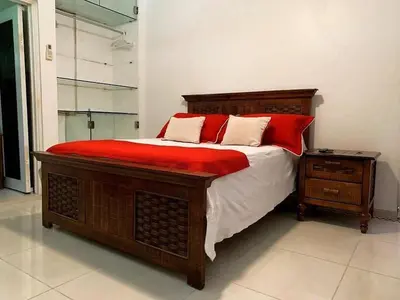 a bedroom with a large bed with red pillows at Cozy Private Room in El Malecn, Santo Domingo in Santo Domingo