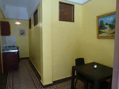 a room with a table and a small table and a kitchen at Residencial La Fonte in Santo Domingo