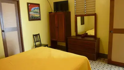 a bedroom with a bed and a dresser and a mirror at Residencial La Fonte in Santo Domingo