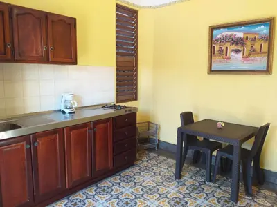 a kitchen with a table and a small table with a stool at Residencial La Fonte in Santo Domingo