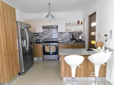 a kitchen with stainless steel appliances and white cabinets at Verano 2019 in Santiago de los Caballeros
