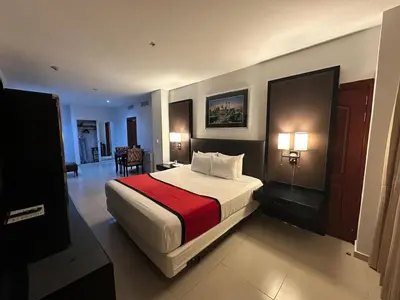 a hotel room with a bed with a red blanket at Ramada by Wyndham Princess Santo Domingo in Santo Domingo