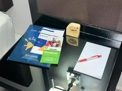 a table with a book and a pen on it at Ramada by Wyndham Princess Santo Domingo in Santo Domingo