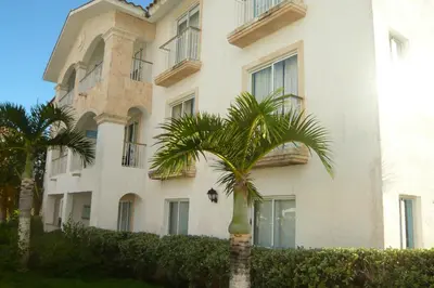 a palm tree in front of a building at The blue lagoon of the Caribbean Sea. Velero 205.Cadaques Caribe in La Fragata