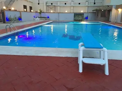 a large swimming pool with a bench in front of it at Matum Hotel & Casino in Santiago de los Caballeros