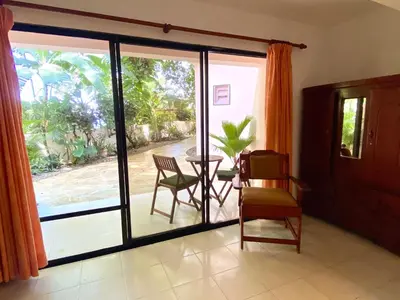 a room with a sliding glass door with a table and chairs at Hotel Alegria in Cabarete