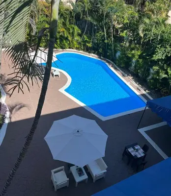 an overhead view of a swimming pool with an umbrella at Calypso Beach Hotel in Boca Chica