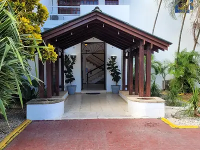 a entrance to a building with plants in front of it at Calypso Beach Hotel in Boca Chica