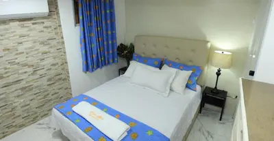 a small bedroom with a bed with a blue headboard at 2 Guests 1bed Studio 3min To Beach And Main Street in Sosúa