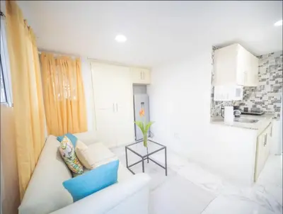 a white living room with a couch and a table at 2 Guests 1bed Studio 3min To Beach And Main Street in Sosúa